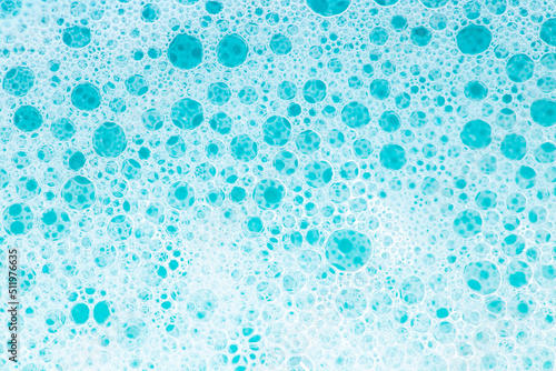 Blue water with white foam bubbles.Cleanliness and hygiene background. Foam Water Soap Suds.Texture Foam Close-up. blue soap bubbles background.Laundry and cleaning background.foam bubbles.