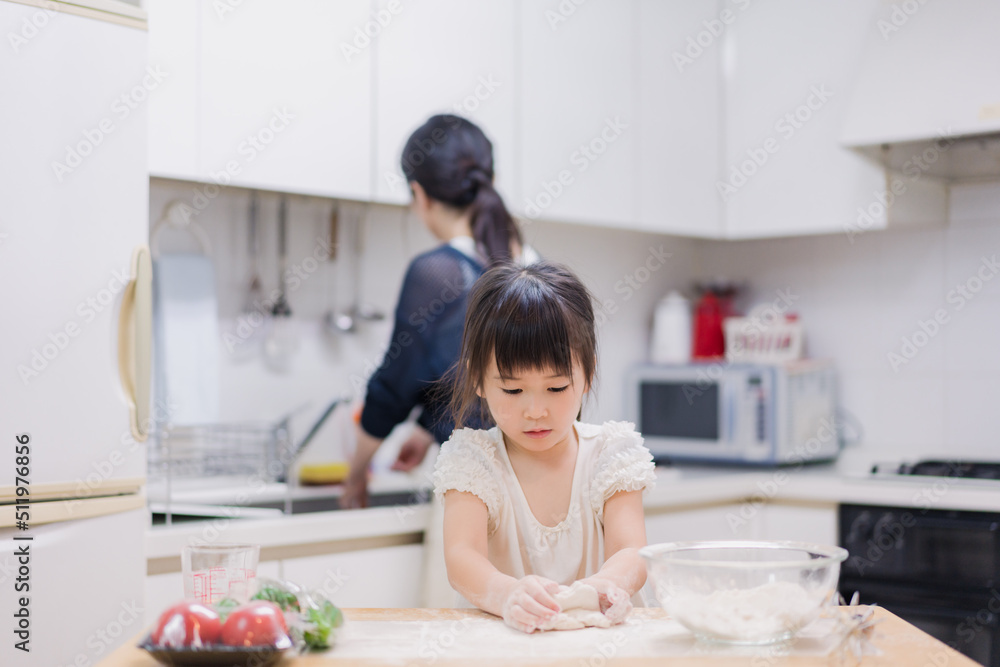 料理を手伝う女の子とお母さん