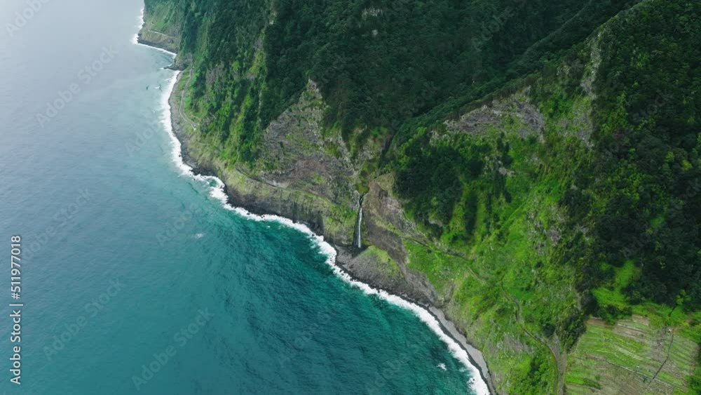 Elevated drone view of cascading waterfall on rocky shoreline; Madeira Elevated drone view of cascading waterfall on rocky shoreline; Madeira
