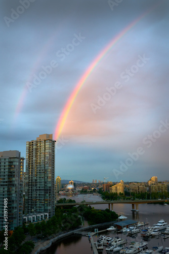 False Creek Rainbow. A rainbow across False Creek at dusk over the Cambie Bridge and towers in Vancouver. British Columbia  Canada.  