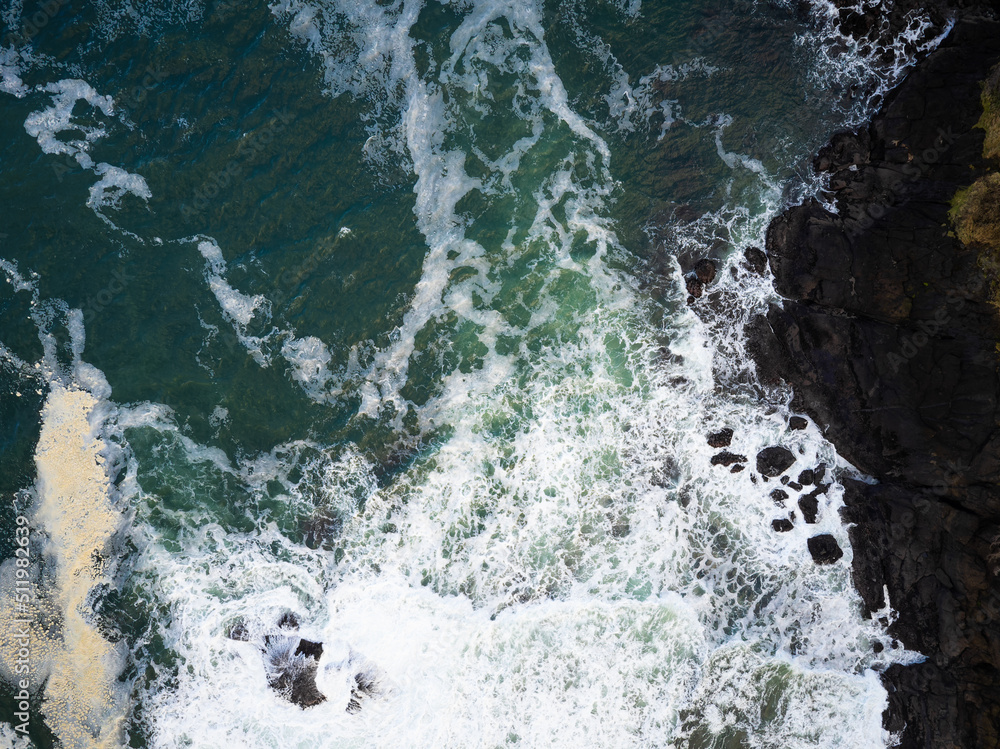 Majestic seascape. View from above. The roaring waves of the ocean break on the rocky shore, a storm. Element, danger, beauty of nature, environmental protection, climate change.