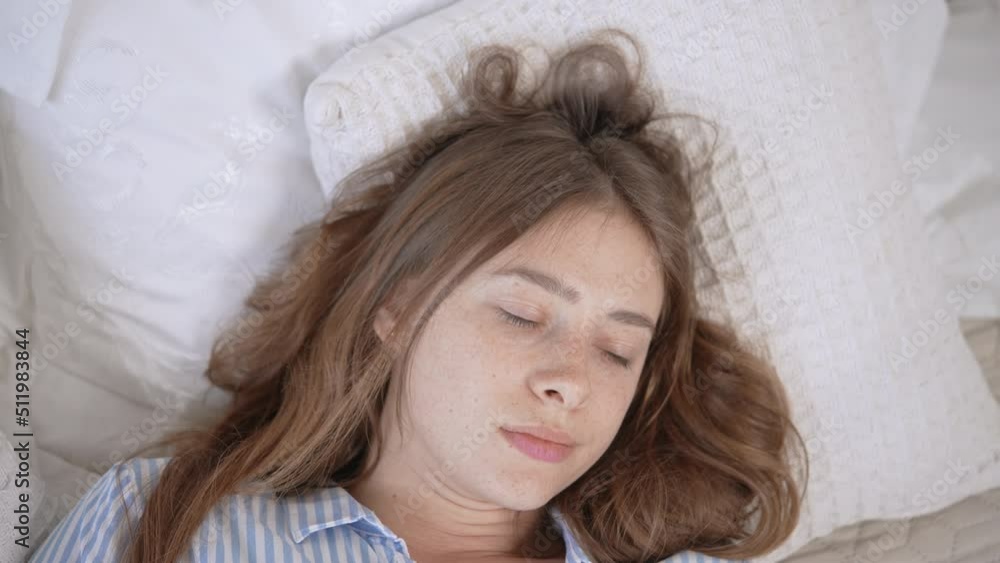 view above on beautiful face young blond woman with freckles lying on pillow wake up smiling looking camera view above on beautiful face young blond woman with freckles lying on pillow wake up smiling looking camera
