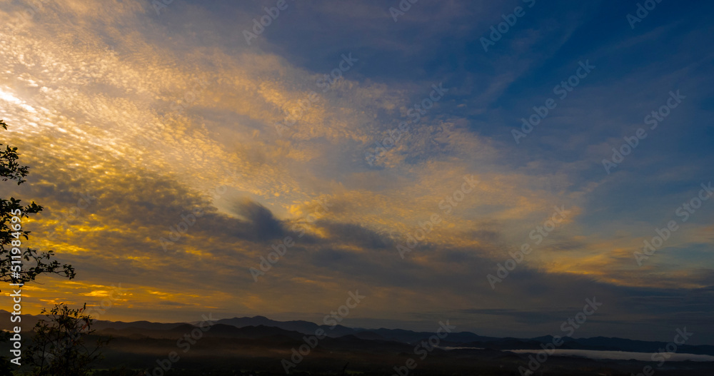Obraz premium Blue golden sky sunrise dramatic beautiful landscape mountain. Dawn sky gold dusk time cloudscape with sunlight. Dramatic sunset over mountain landscape. Beautiful landscape foggy hills twilight time