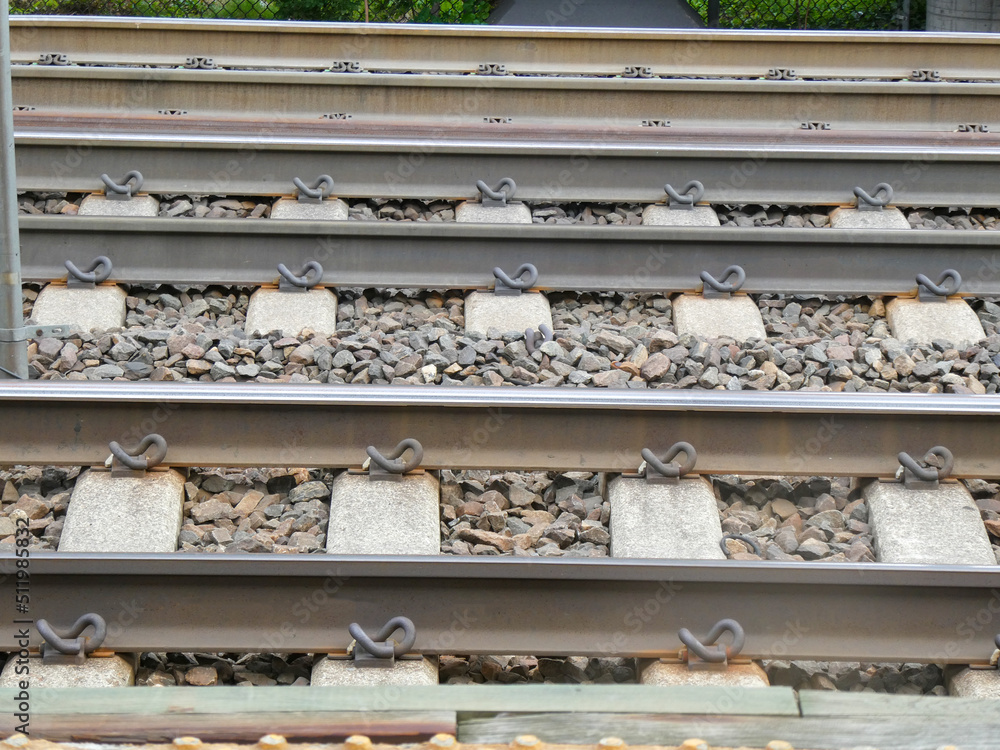 Close up view of steel railroad tracks on a gravel bed with concrete ties