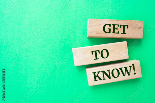 Get to know words on wooden blocks on green background.