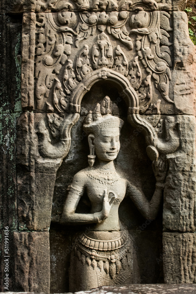 A sandstone sculpture of Apsara looking in a mirror at Ta Som Temple in Siem Reap Angkor Wat, Cambodia.