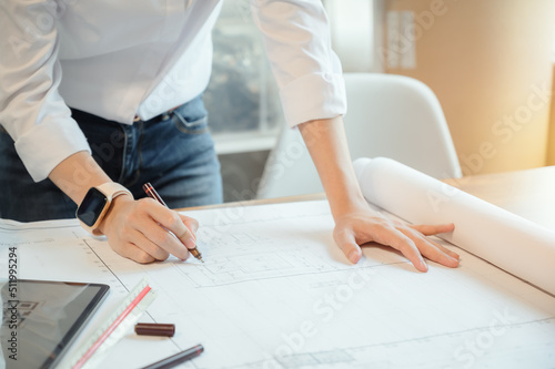 Selective focus, Asian female architect or engineer Drawing the design of the building structure in the blueprint. Asian female architect or engineer Sit and analyze, design projects in the office.