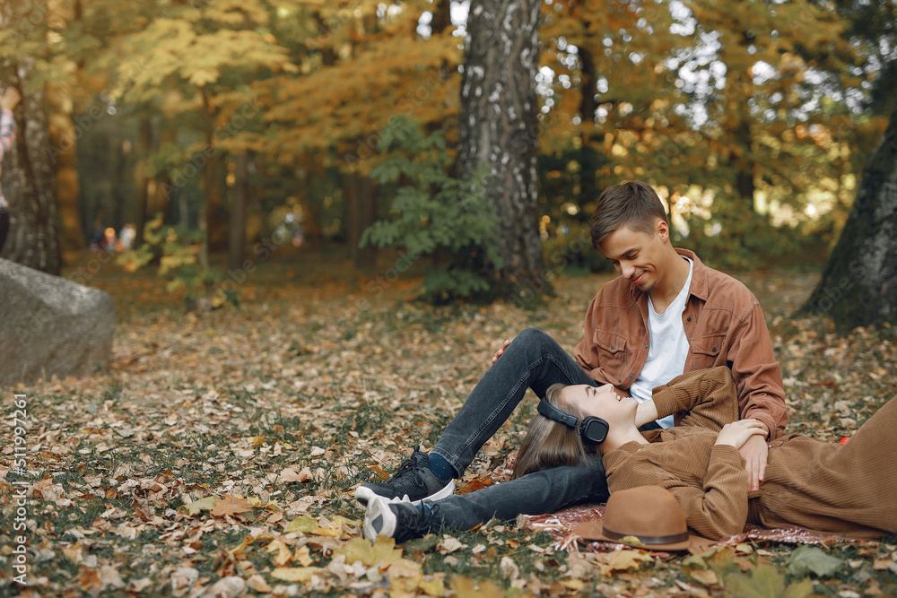 Fototapeta premium Beautiful couple spend time in a autumn park