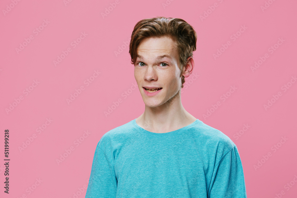 portrait of a cute, pleasant, smiling guy in a blue t-shirt on a pink background with space for text portrait of a cute, pleasant, smiling guy in a blue t-shirt on a pink background with space for text