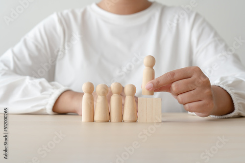 Woman and wooden human figures concept of recuitment, leadership, teamwork. Winner was pick up and loser was ignore. photo