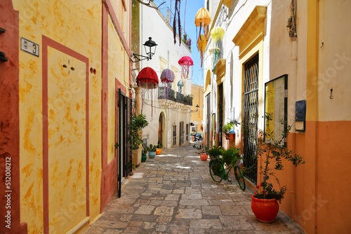A narrow street between the old houses of Gallipoli, an old village in the province of Lecce in Italy. photo