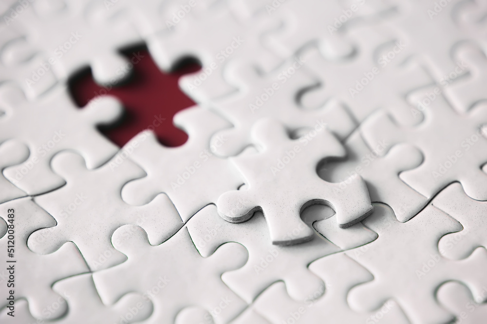 Clean puzzle elements on the red background. Empty puzzle piece on the table. Teamwork concept. Clean puzzle elements on the red background. Empty puzzle piece on the table. Teamwork concept.