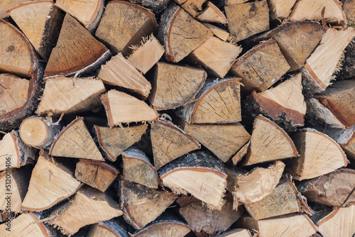 A pile of stacked birch firewood for the stove. Firewood in the woodpile. Natural background.
