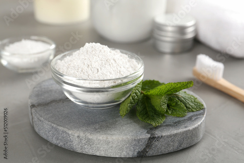 Tooth powder and mint on grey table, closeup