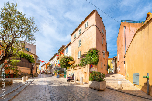 Fototapeta Naklejka Na Ścianę i Meble -  Colorful shops and buildings line the narrow, hilly alleys and streets in the Old town area of Saint-Tropez, France.