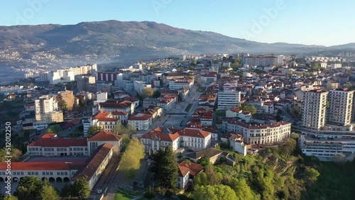 Picturesque drone view of Vila Real cityscape in valley framed by Serra do Alvao and Serras do Marao mountains in light fog on sunny spring day, Portugal photo