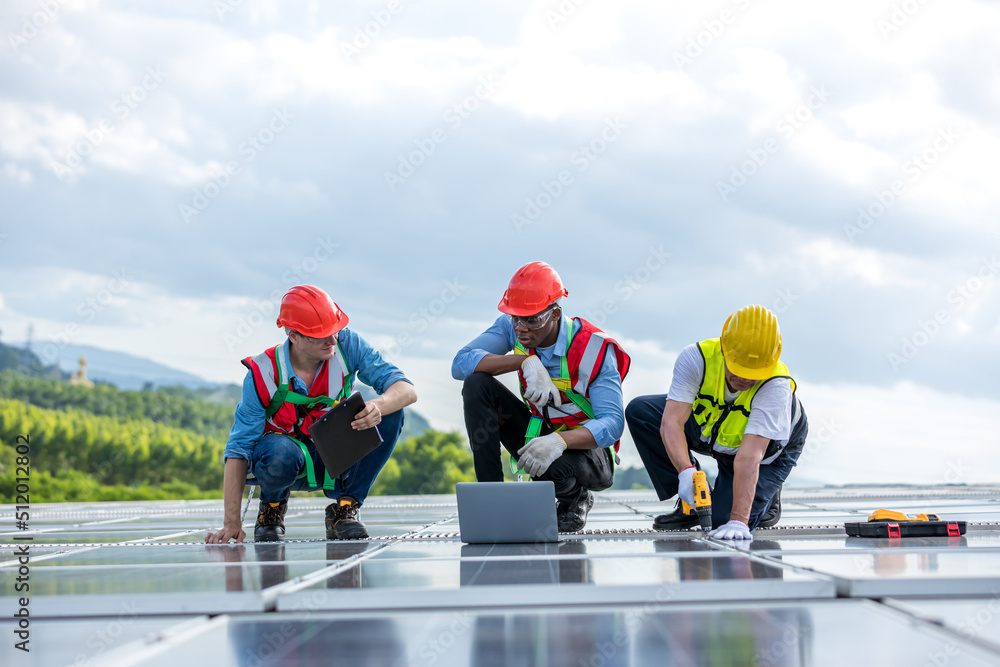 Engineer working setup Solar panel at the roof top. Engineer or worker work on solar panels or solar cells on the roof of business building Engineer working setup Solar panel at the roof top. Engineer or worker work on solar panels or solar cells on the roof of business building