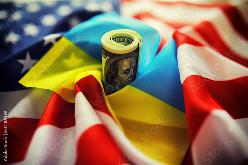 Ukrainian and American flags, a pack of American dollars. Aid and lend-lease concept. photo