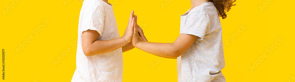 Cute little girls playing on yellow background Cute little girls playing on yellow background