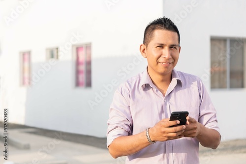 Hispanic man checking smartphone. Casual Ecuadorian man. Copyspace.