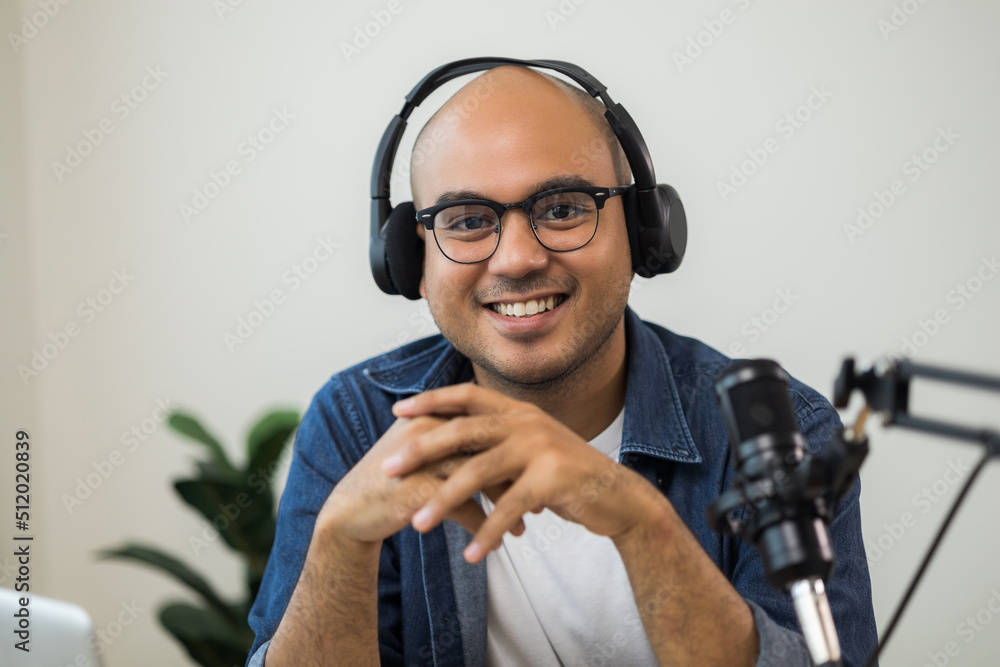 Content creator asia man host streaming his a podcast on laptop with headphones and condenser microphone interview guest conversation at home broadcast studio. Male blogger recording voice over radio Content creator asia man host streaming his a podcast on laptop with headphones and condenser microphone interview guest conversation at home broadcast studio. Male blogger recording voice over radio