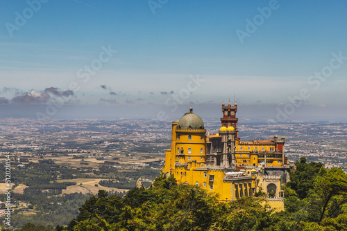 Obraz na plátně A yellow and red palace in Sintra, Portugal sits on a hilltop surrounded by tree