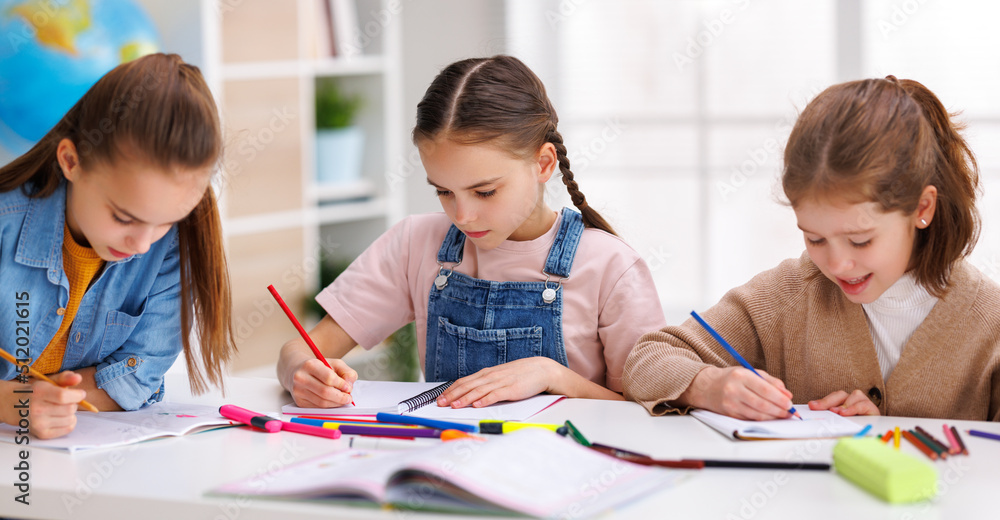 Cheerful girl solving test with classmates