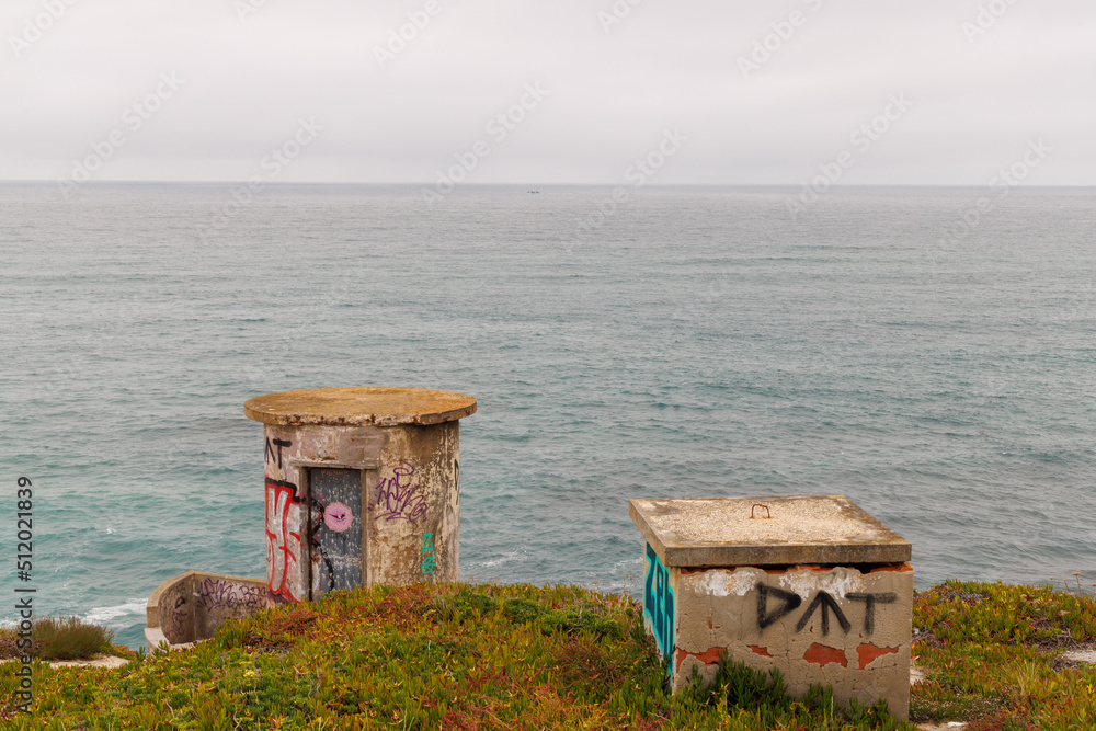 Two graffiti covered concrete bunkers overlook the Atlantic Ocean