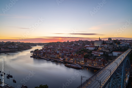 The cityscape of Porto with a bridge in the foreground at sunset and nightfall © Harrison
