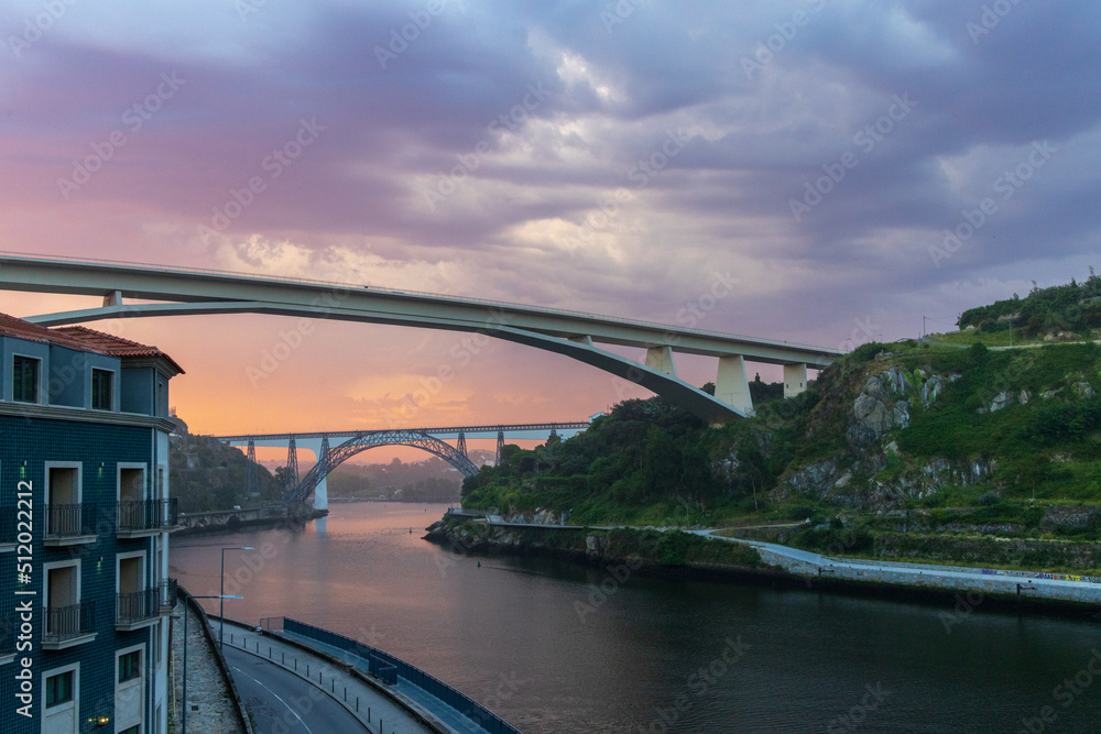 Fototapeta premium Morning light creates colorful pink clouds over a river in Porto, Portugal