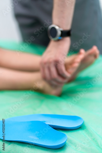 Male orthopedist checking patient's foot in clinic