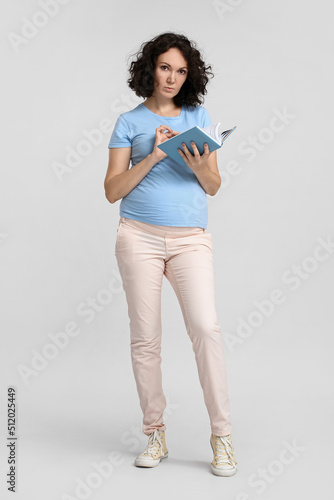 Young pregnant woman readin...