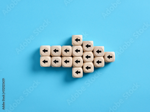 Arrow icon made of wooden cubes with little arrow icons pointing opposite direction. Resistance to change in business photo