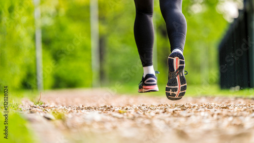 Young woman wearing sport shoes jogging in park