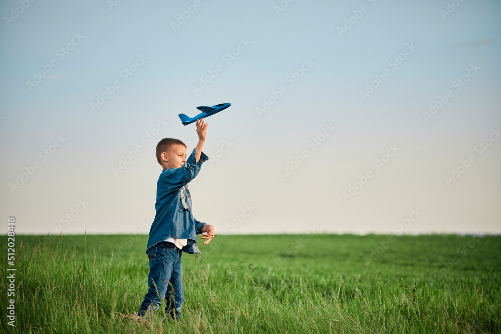 Boy throwing airplane toy in field on weekend Boy throwing airplane toy in field on weekend