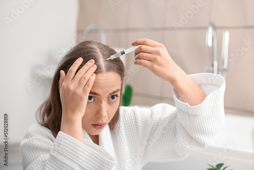 Young woman with hair loss ...