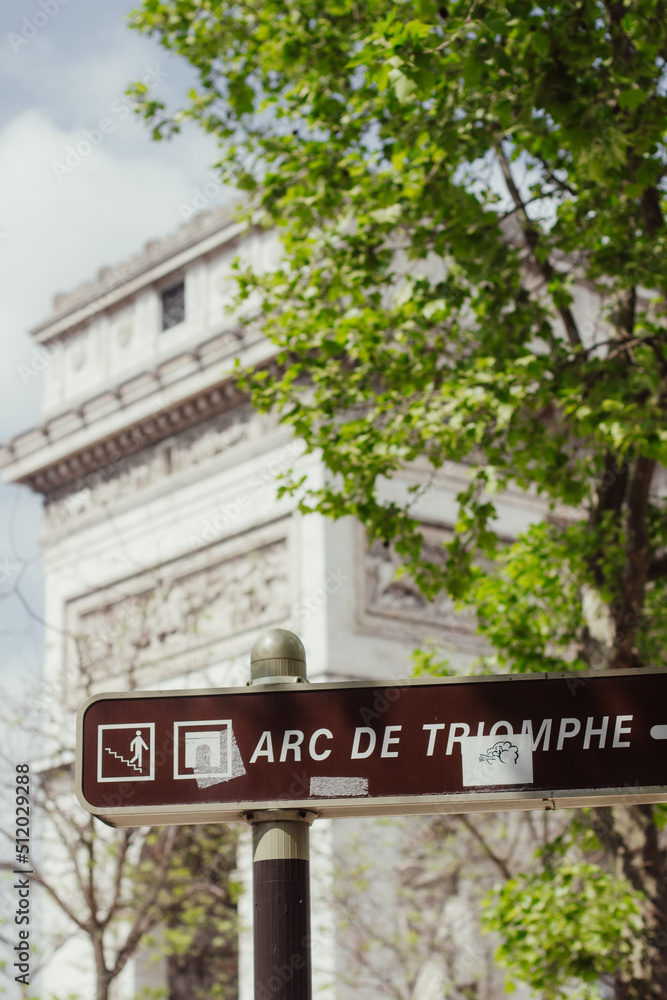 A picture of the Arc de Triomphe behind a street sign A picture of the Arc de Triomphe behind a street sign