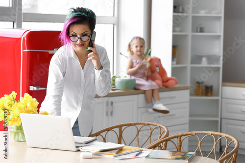 Mother working with laptop ...