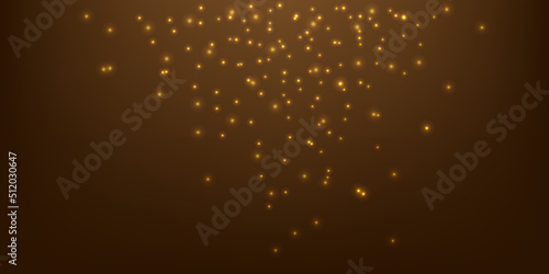 Golden sparkles on brown background. Bright dust sparkles on a brown background. Christmas or holiday card decoration.
