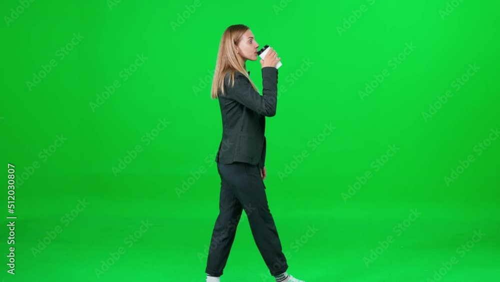 Businesswoman in a suit walking down the street and drinks coffee on a green background, a passerby on a walk, side view, chroma key template. Businesswoman in a suit walking down the street and drinks coffee on a green background, a passerby on a walk, side view, chroma key template.