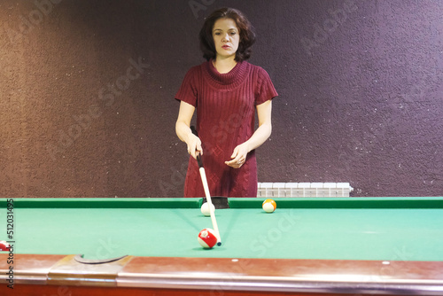 a woman takes aim at a billiard ball © Seroma72