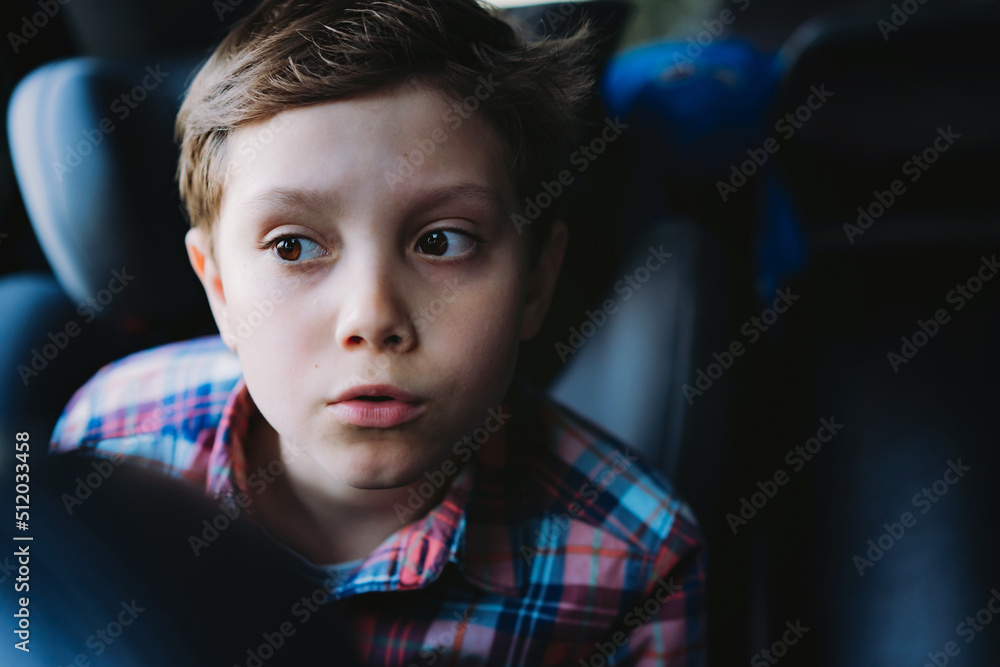 Handsome caucasian boy travelling by car sitting in child seatRecreation concept Handsome caucasian boy travelling by car sitting in child seatRecreation concept