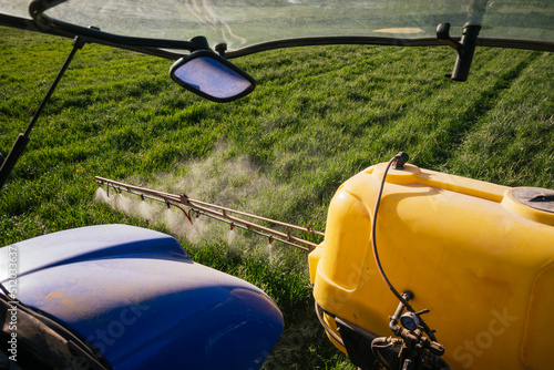 Crop sprayer spraying fertilizer on field photo
