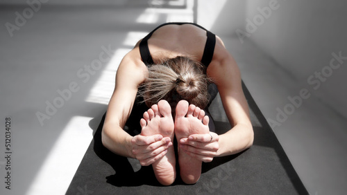 Young woman practicing yoga in class, doing exercises and meditating. Yoga, meditation, relaxation, self care, healthy lifestyle, fitness, workout, pilates exercising concept