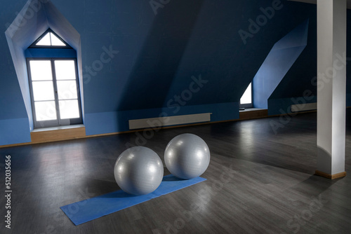 Gray color exercise balls on mat in empty fitness room photo