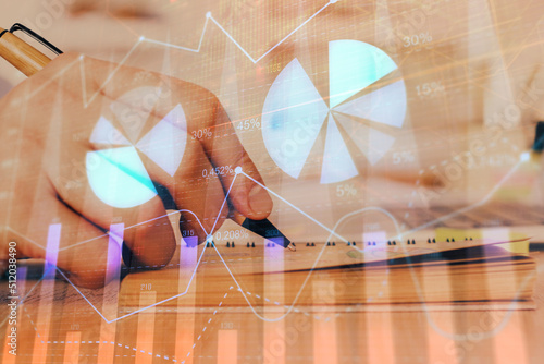 Double exposure of man doing notes of stock market with forex graph.