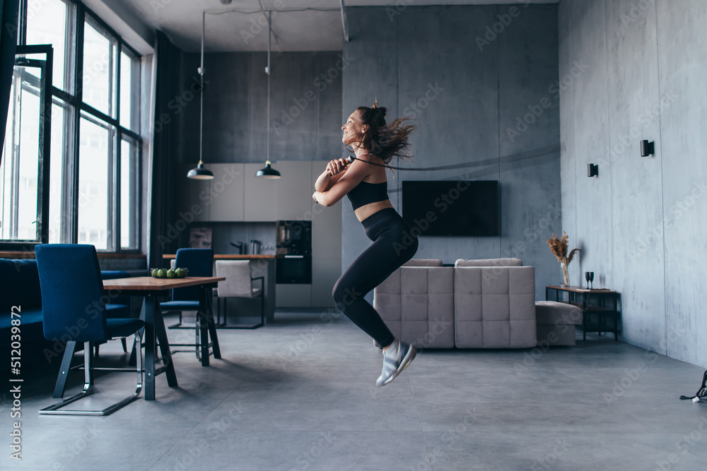 Girl exercising with jumping rope at home. Fit woman skipping rope. Stock Photo Adobe Stock