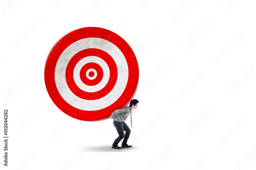 Businessman carrying a big dartboard on studio Businessman carrying a big dartboard on studio