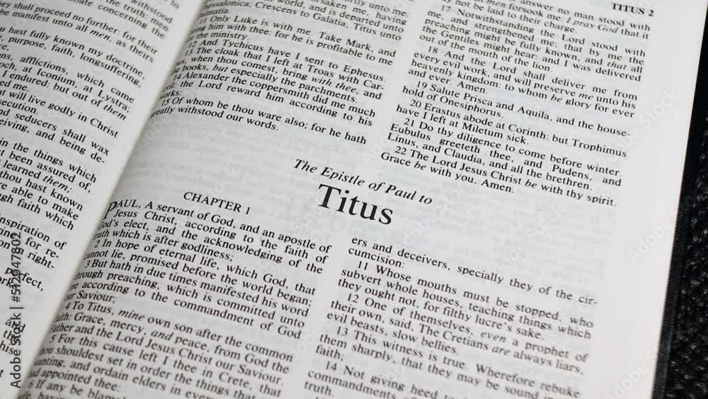 Close Up Shot of Bible Page Turning to the book of Titus Close Up Shot of Bible Page Turning to the book of Titus