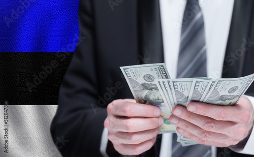Hands holding dollar money on flag of Estonia